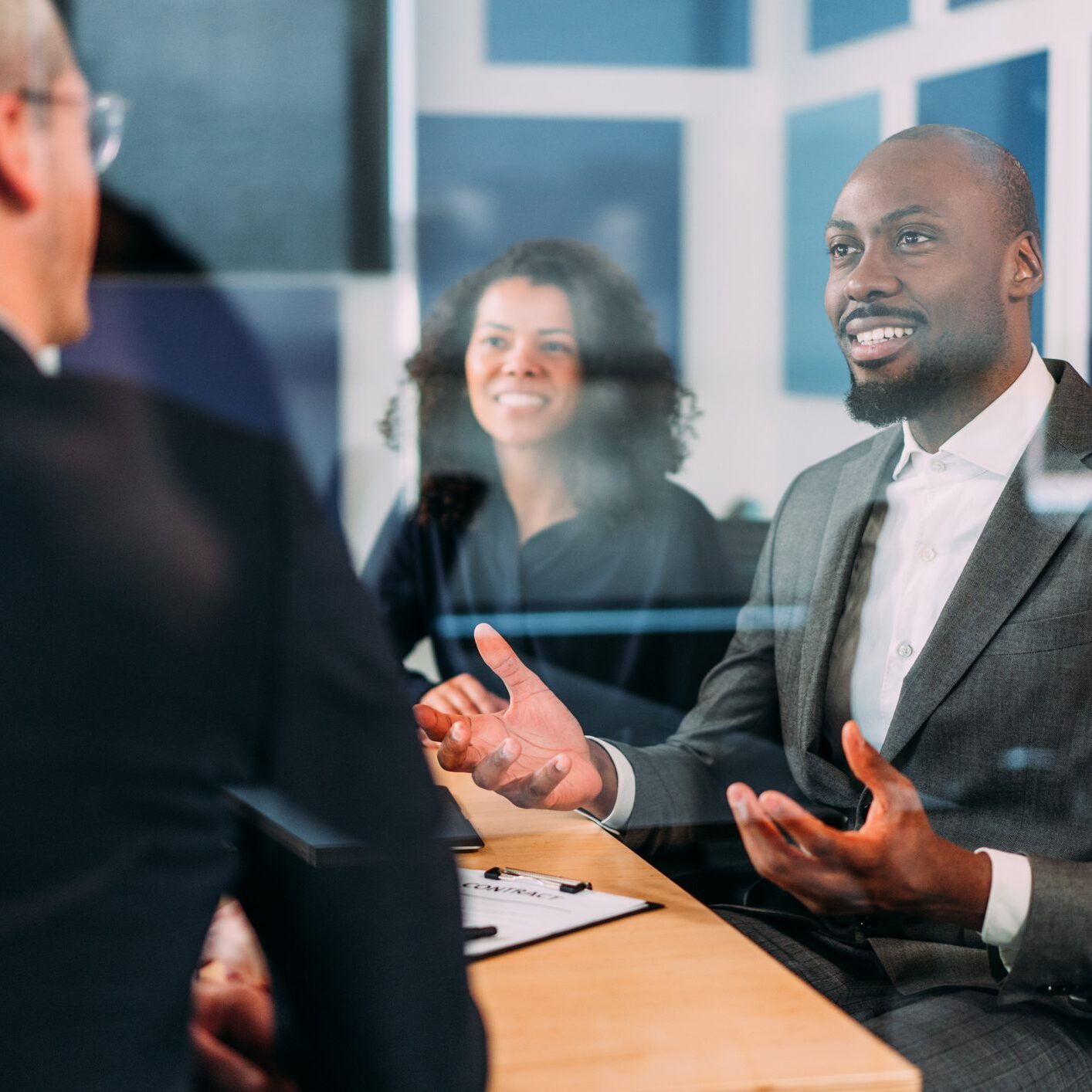 Group of business persons in business meeting. Group of entrepreneurs on meeting in board room. Creative business team on meeting in the office. The view is through glass.